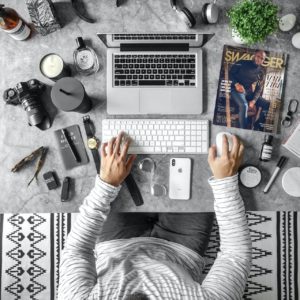 man on laptop with gadgets all around him